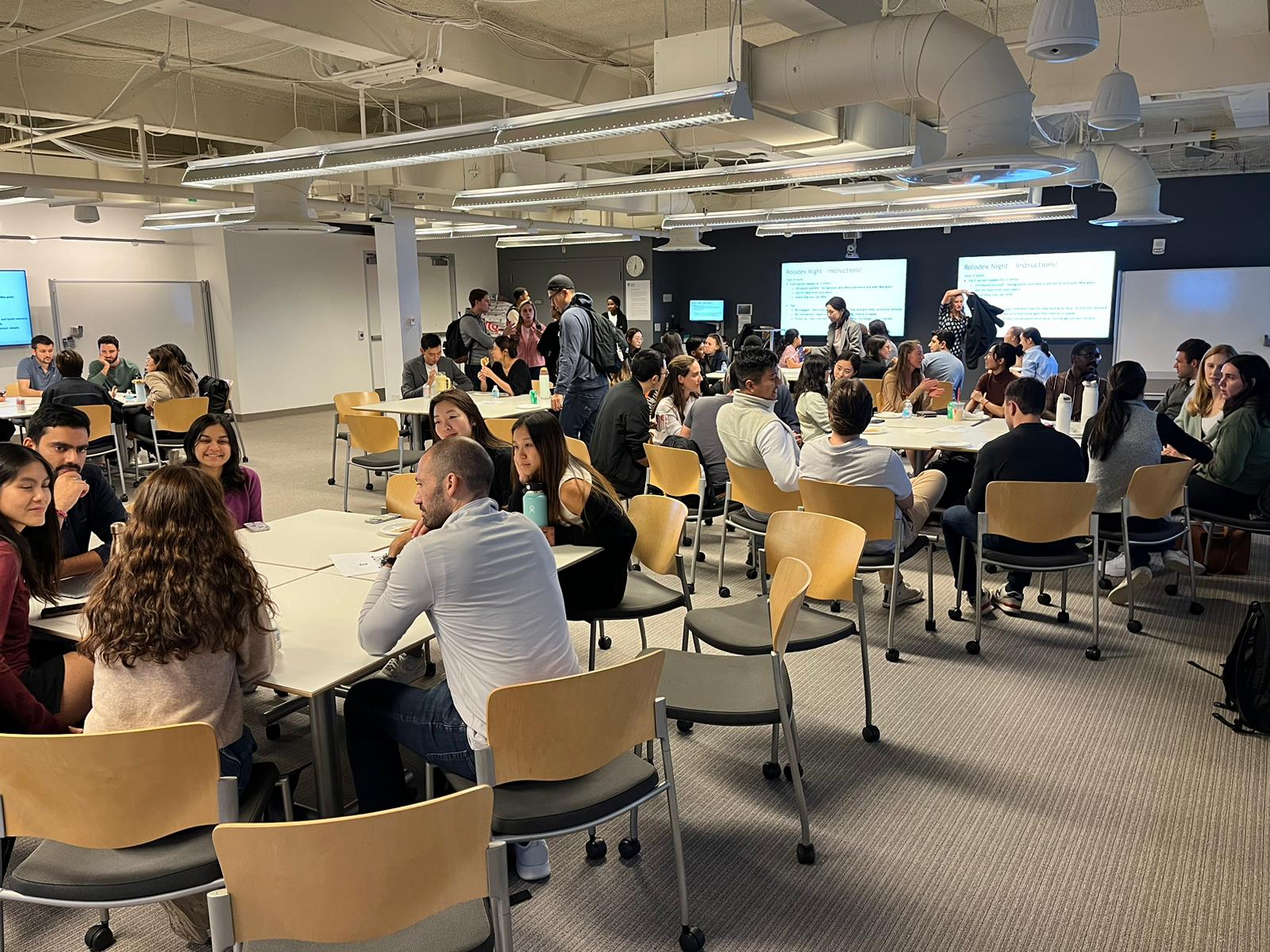 Students networking around roundtables